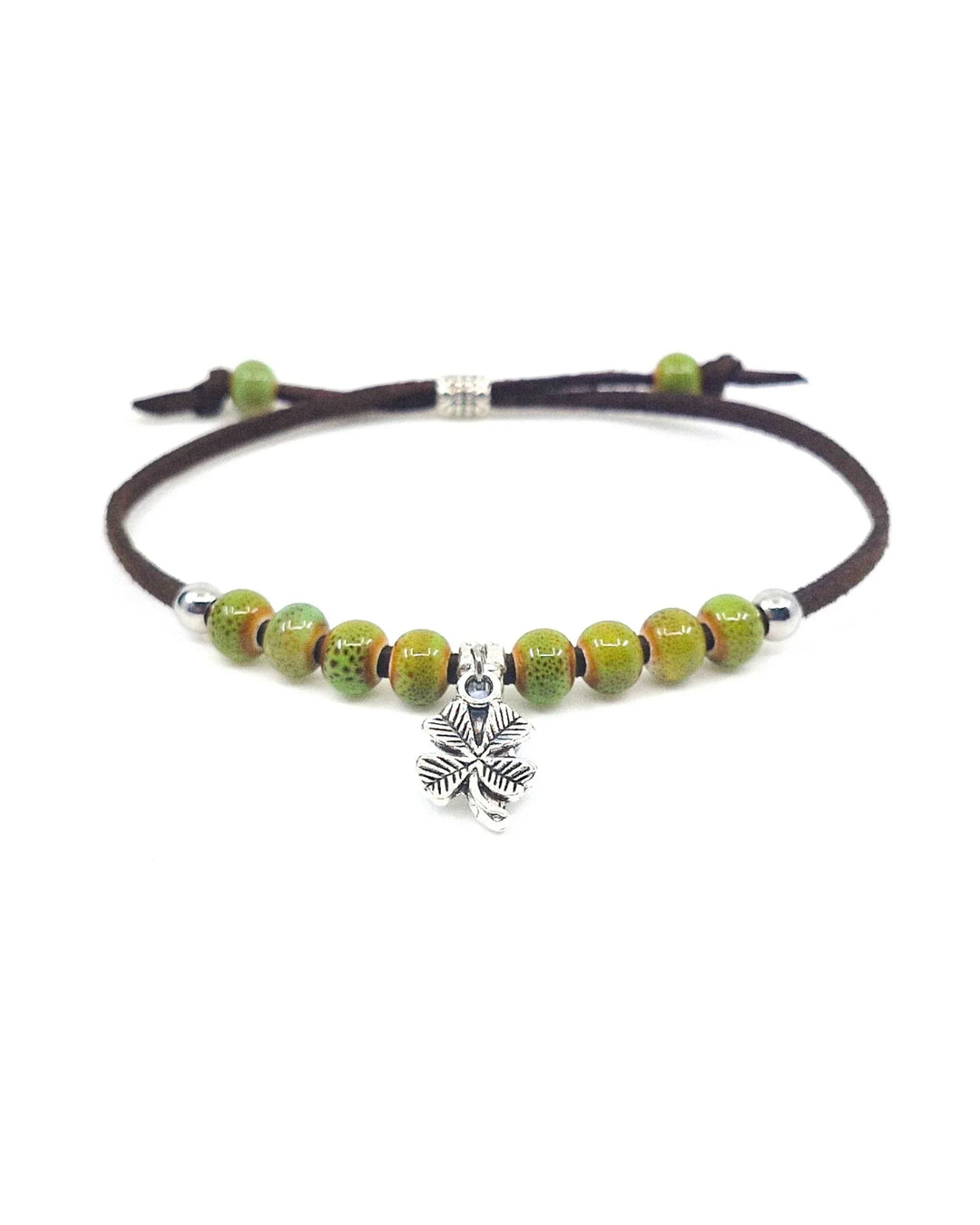 Shamrock charm bracelet with green ceramic beads and adjustable brown cord on white background