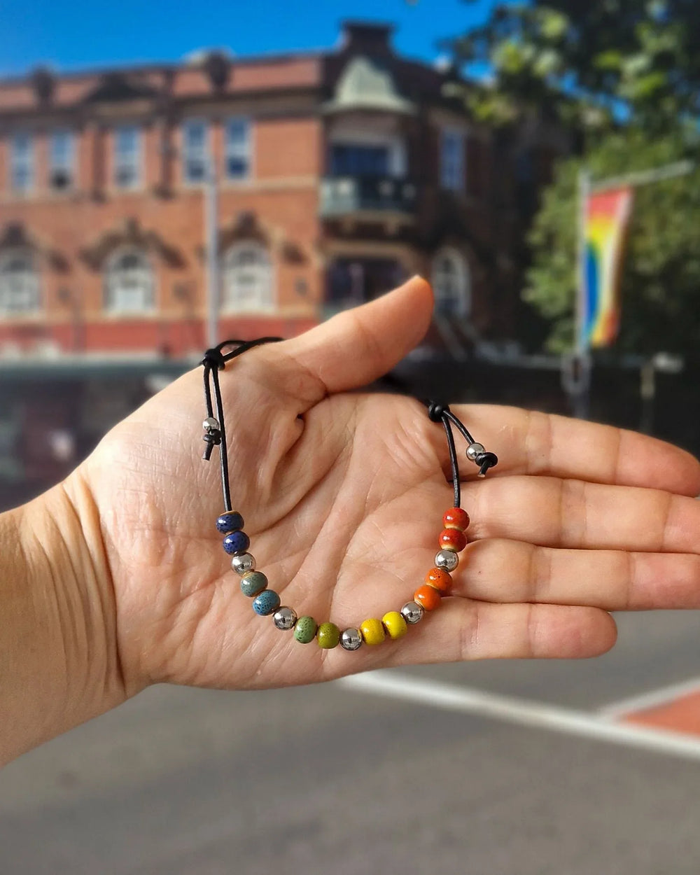 Rainbow Pride anklet featuring colourful ceramic beads on black faux leather cord