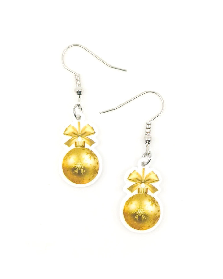 2D gold Christmas bauble earrings with a gold bow and snowflake print, hanging from silver hooks