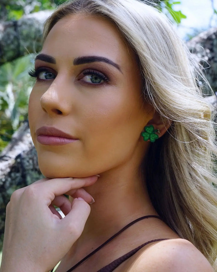 Model wearing green glitter shamrock stud earrings, showing fit and festive St Patrick’s Day style