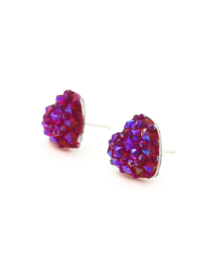 Close up of sparkly heart shaped earrings in hot pink