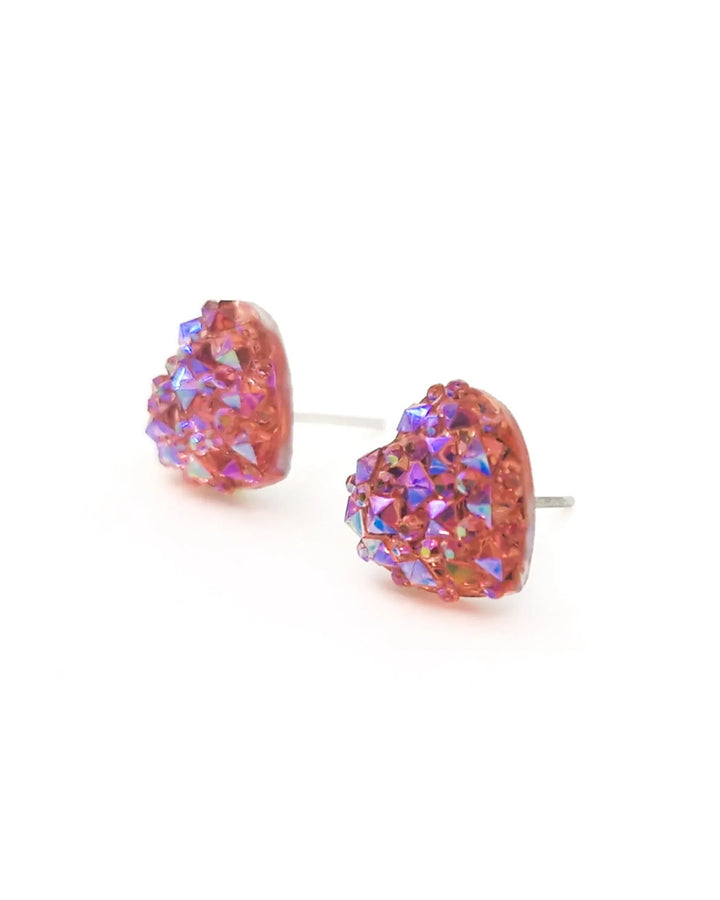 Close up of sparkly heart shaped earrings in pale pink