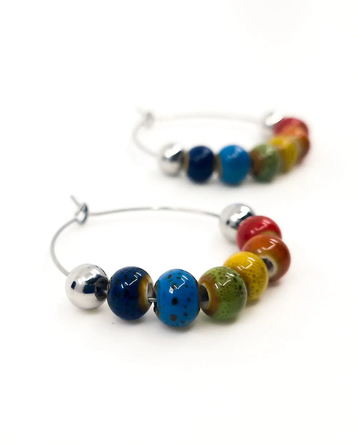 Close-up of Rainbow Pride hoop earrings showing rainbow ceramic bead details