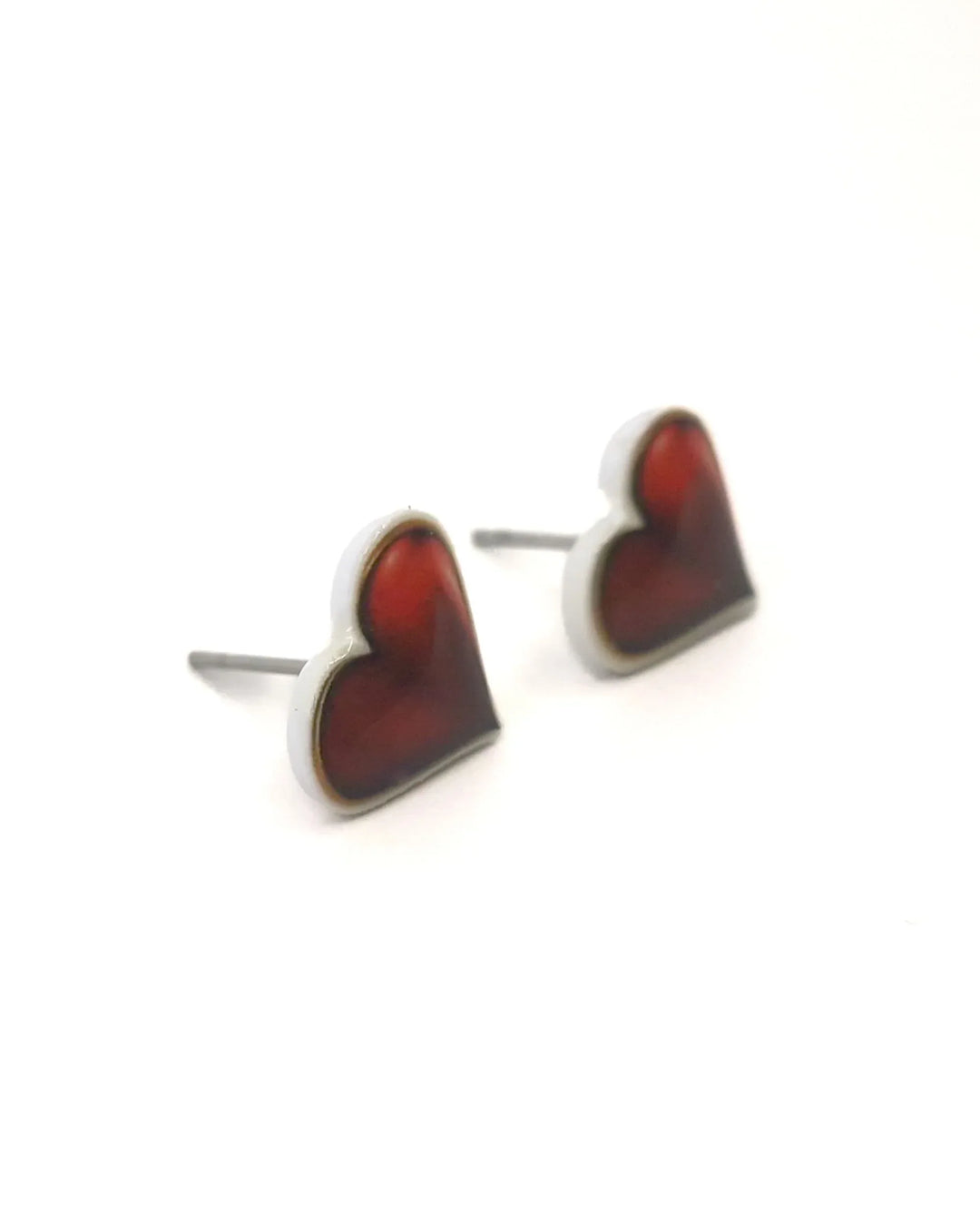 Close-up of shiny red heart stud earrings highlighting glossy red heart design