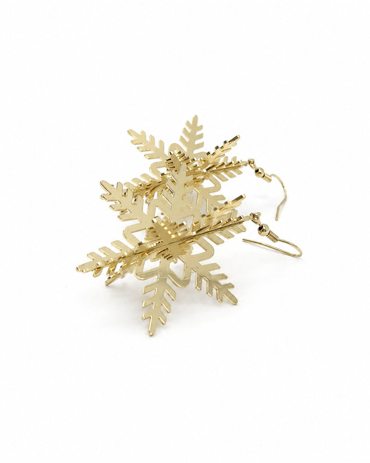 Angled view of 3D gold snowflake earrings showing the crossed panels and depth