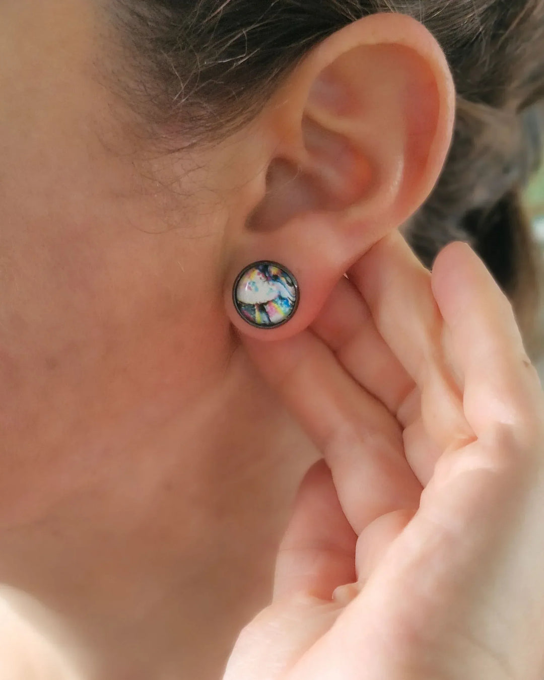 Model wearing abstract rainbow stud earrings showing size and fit