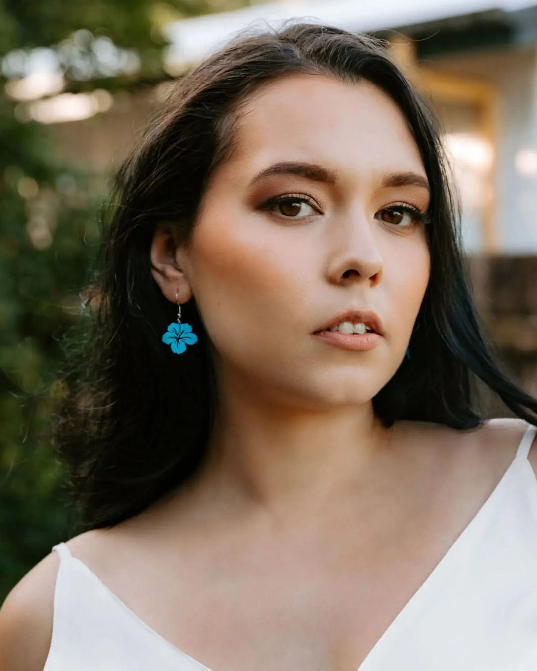 Model wearing purple filigree hibiscus drop earrings showing size and fit