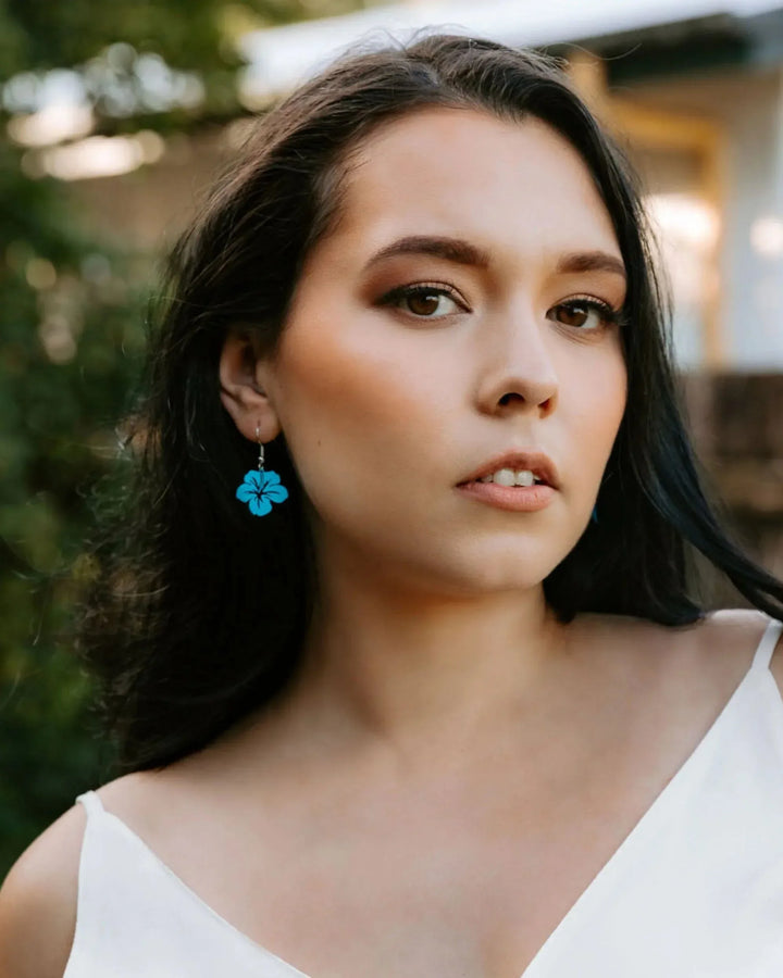 Model wearing purple filigree hibiscus drop earrings showing size and fit