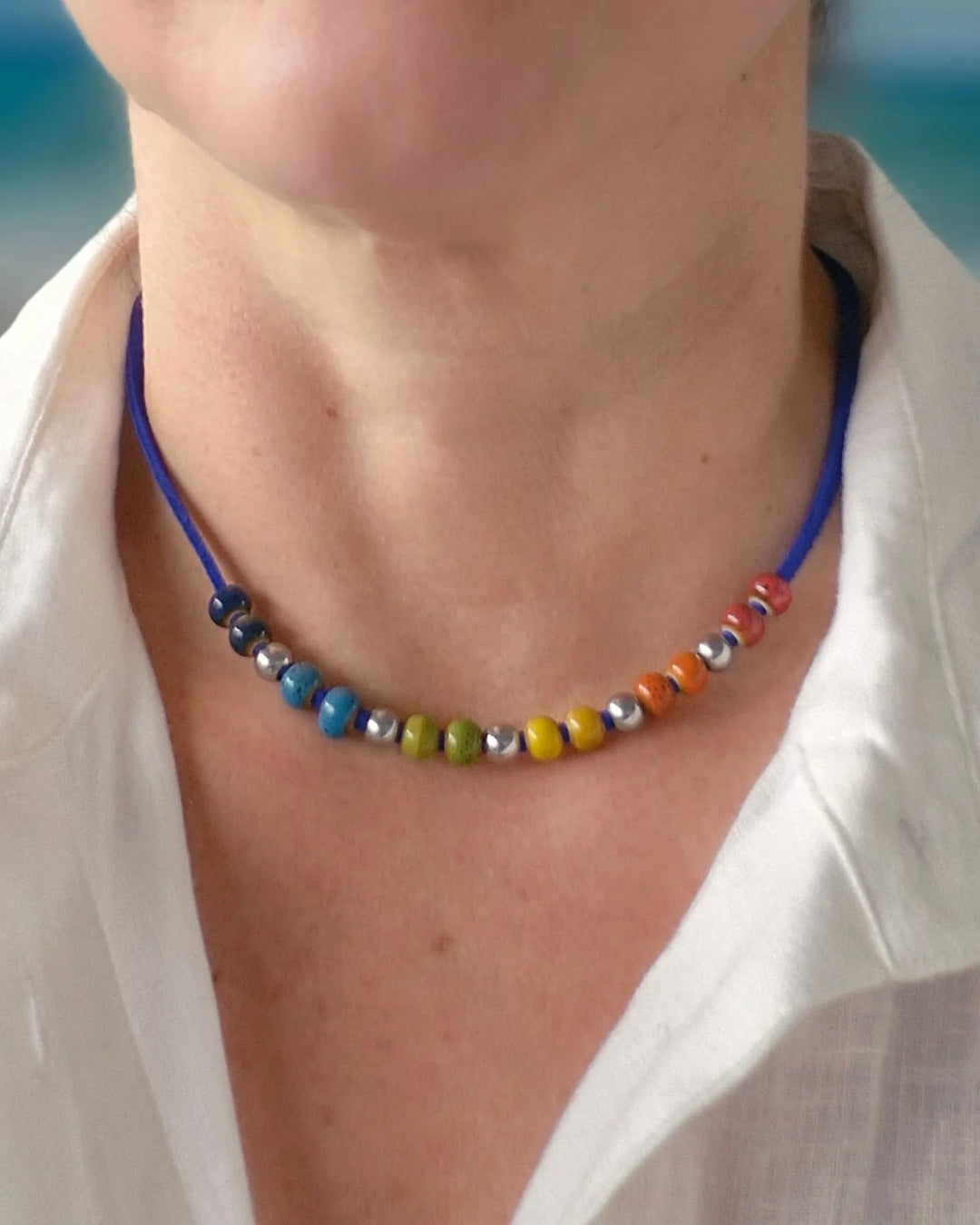 Model wearing Rainbow Pride necklace with rainbow ceramic beads for Pride and Mardi Gras