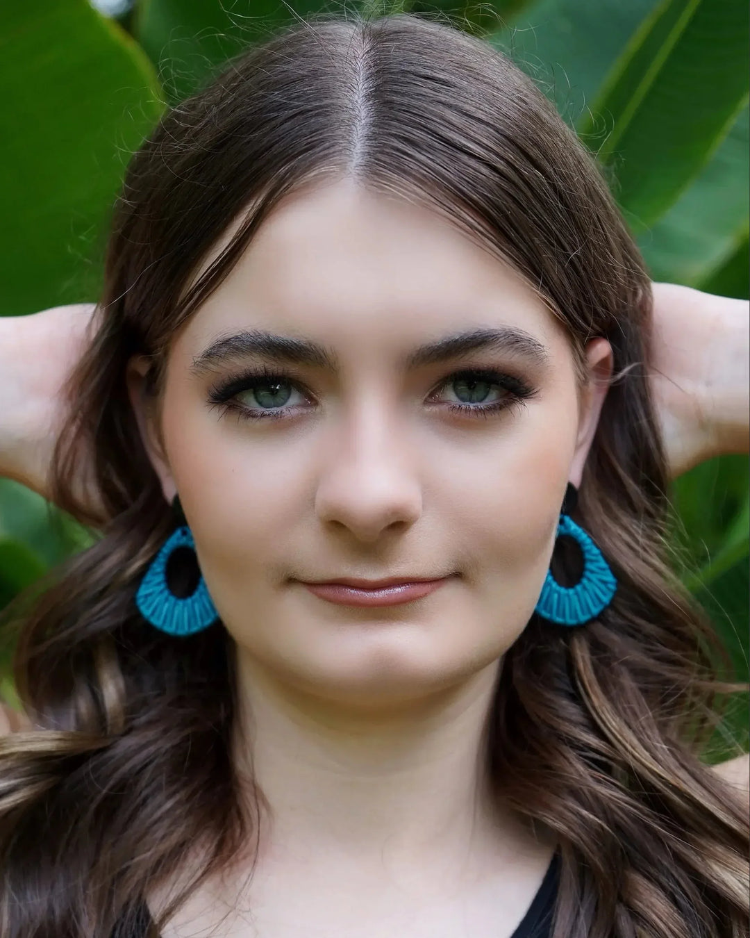 Model wearing light blue acrylic woven stud drop earrings with black round stud top
