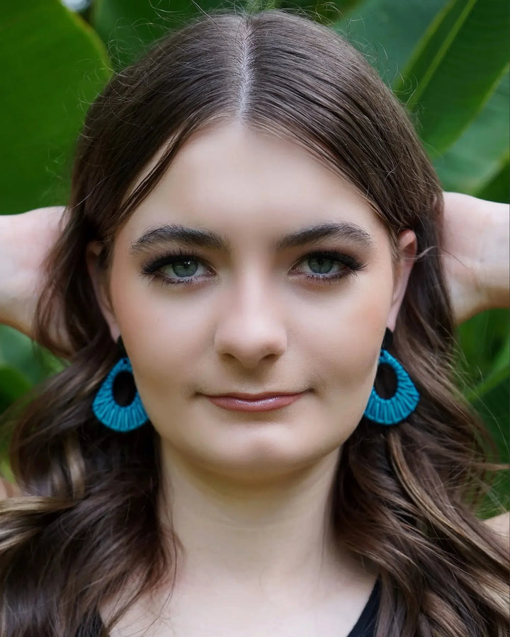 Model wearing light blue acrylic woven stud drop earrings with black round stud top