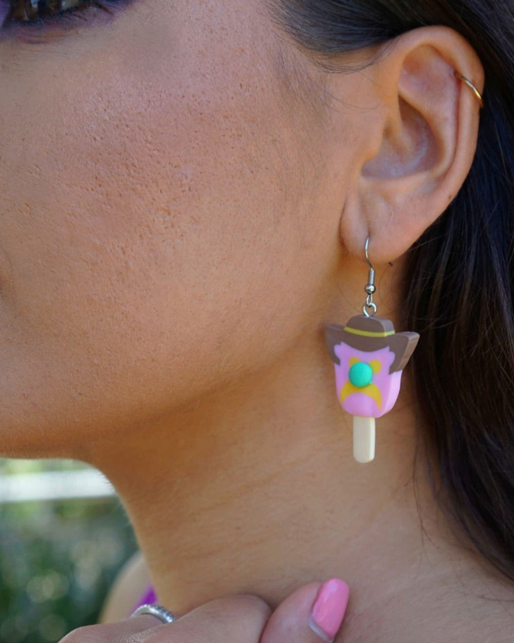 Bill ice cream character drop earring worn on ear in pink, brown and yellow polymer clay