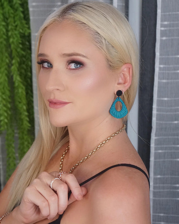 Side view of light blue acrylic woven stud drop earrings worn on ear with black stud top