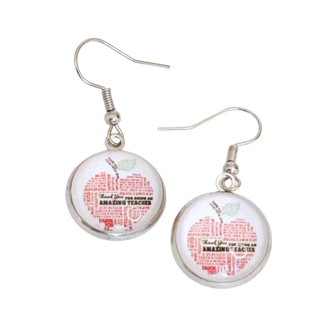 “Glass cabochon teacher earrings featuring an apple made of affirmation words in rhodium tray on stainless steel hooks”