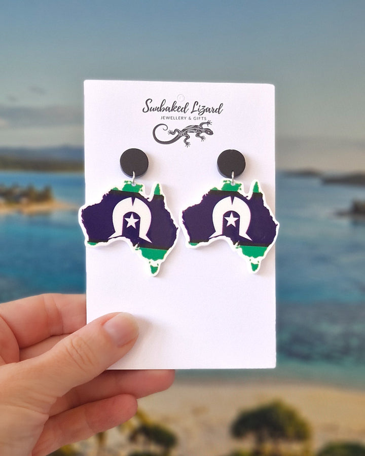 Australia Earrings - Torres Strait Island Flag on a white Sunbaked Lizard Jewellery &amp; Gifts card held against an island background