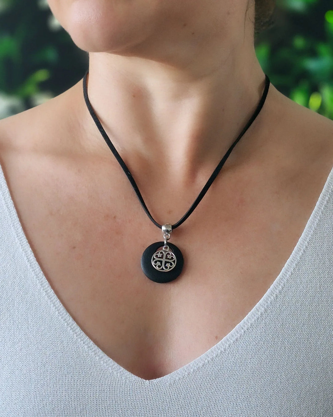 Model wearing Black Circle of Hearts charm necklace with silver heart charm