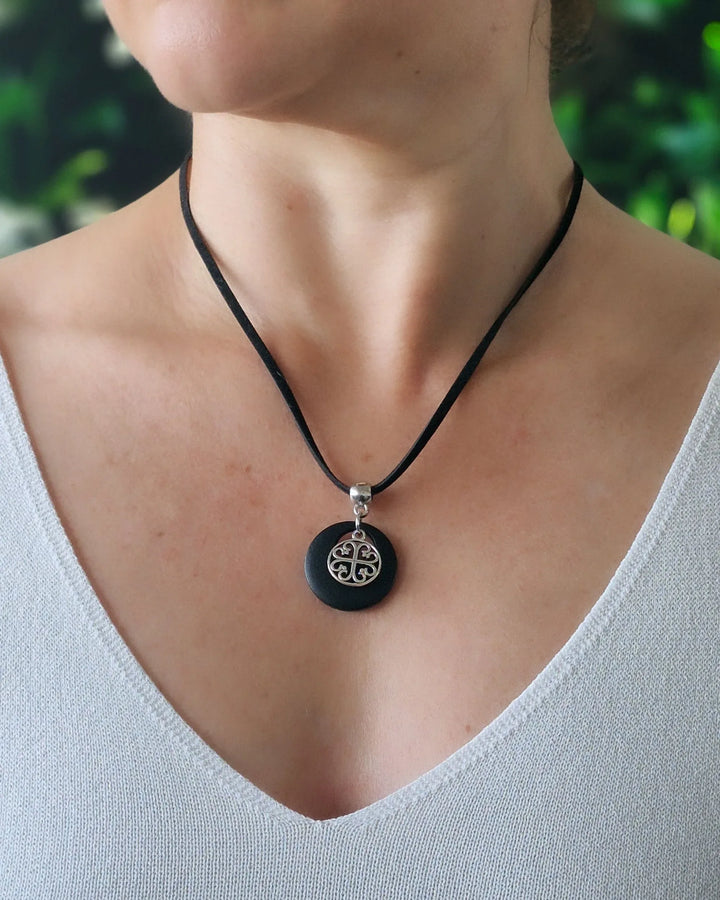 Model wearing Black Circle of Hearts charm necklace with silver heart charm