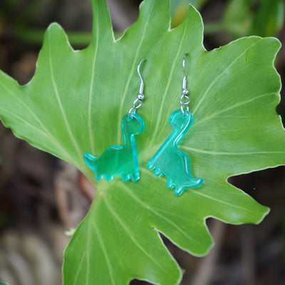 Blue Dino The Dinosaur Dangles resting on a large green leaf