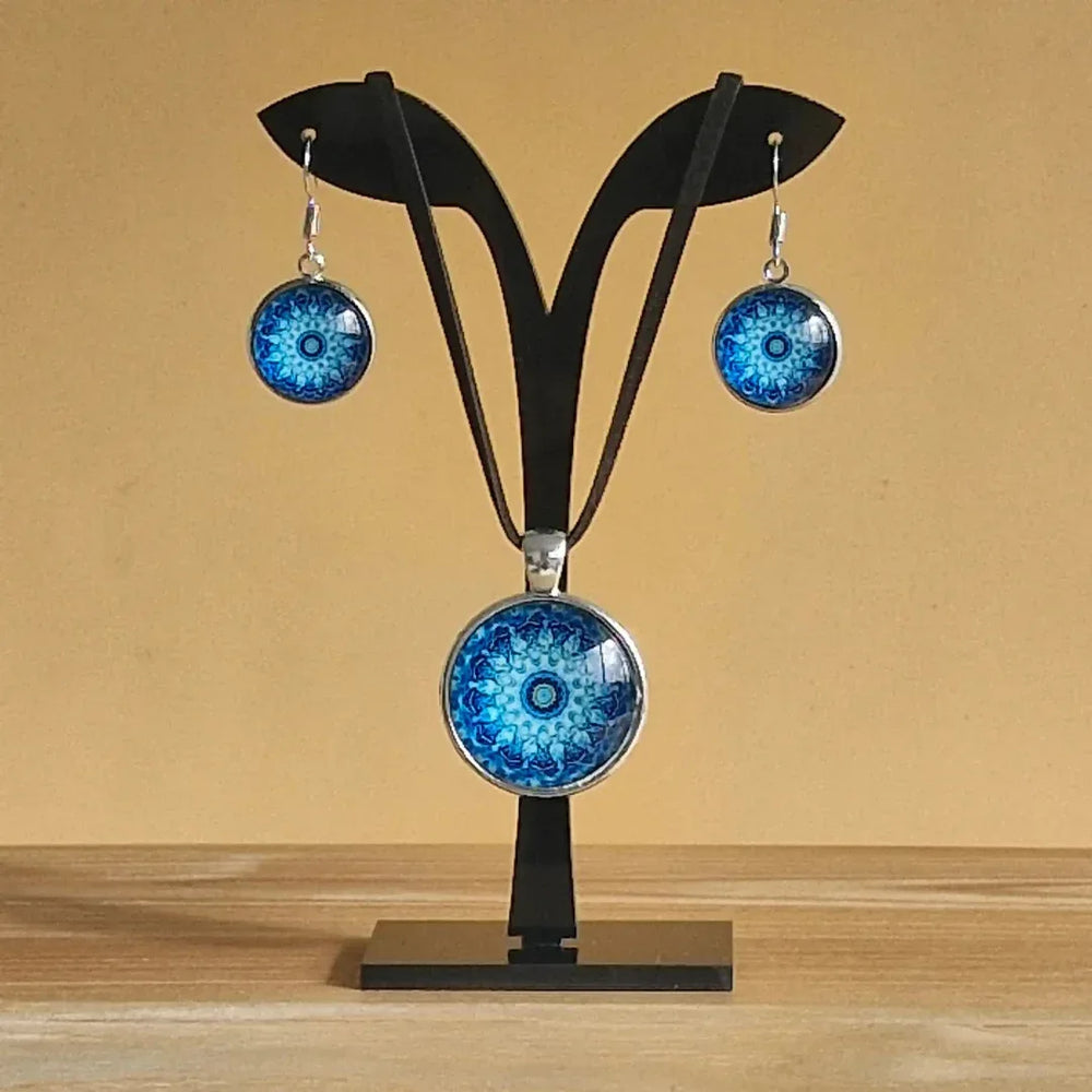 Pair of earrings with blue mandala design and matching necklace displayed on a jewellery stand