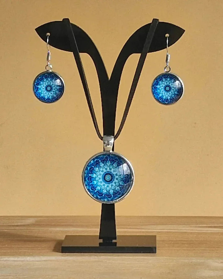 Pair of earrings with blue mandala design and matching necklace displayed on a jewellery stand