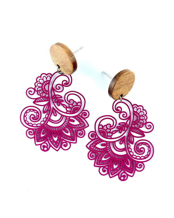 Close up of vibrant pink lace pattern drop earrings with intricate swirling details