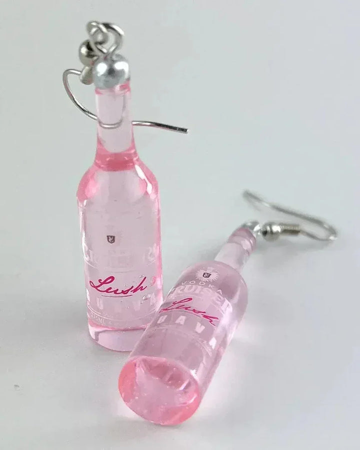 Alcohol earrings in a pink translucent vodka bottle shape on a white background
