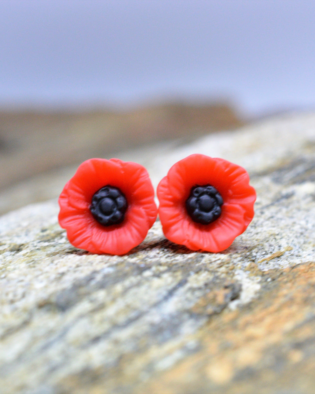 Red poppy stud earrings on sandstone rock