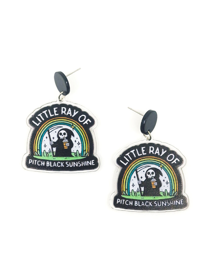 Little Ray of Pitch Black Sunshine earrings with cartoon grim reaper holding iced coffee under rainbow