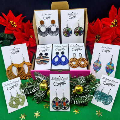 Assorted earrings on display with decorative poinsettias and greenery.