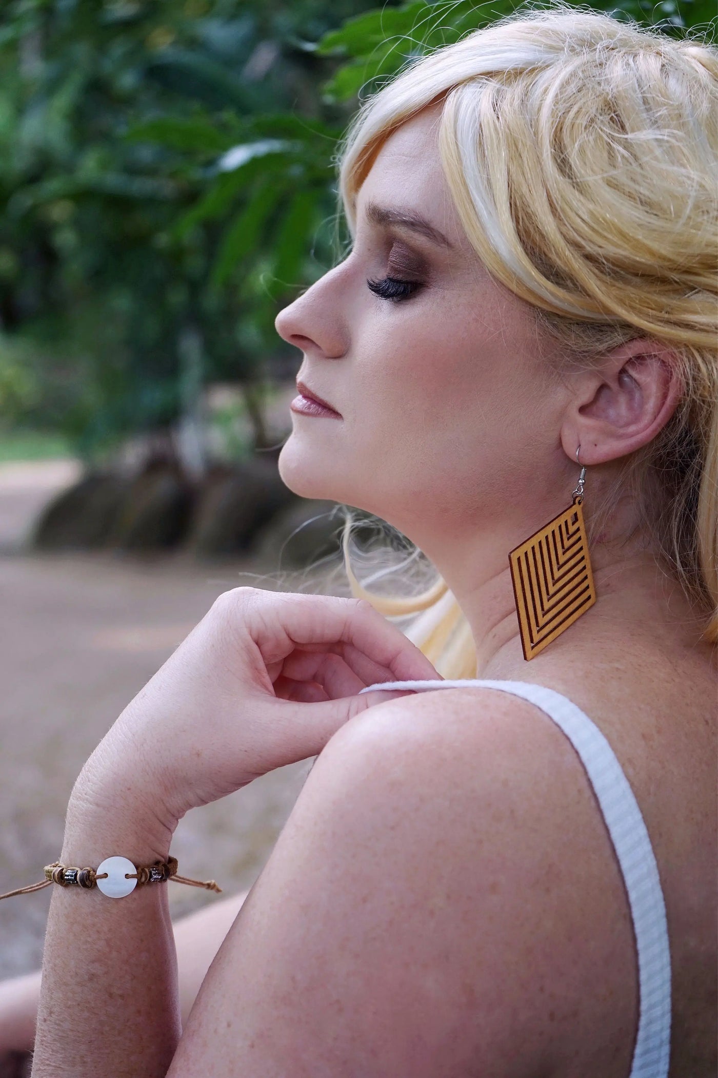 Woman wearing a shell bracelet with a blurred natural background