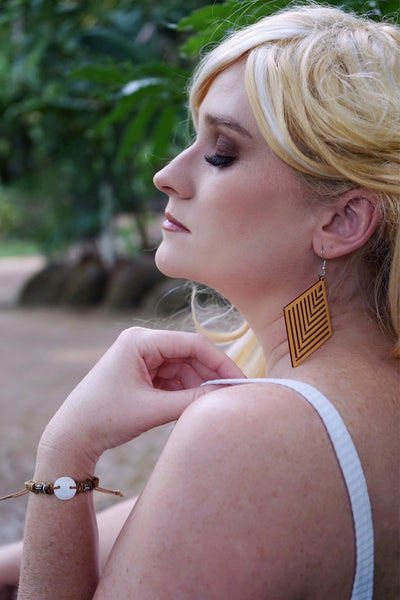 Woman wearing a shell bracelet with a blurred natural background