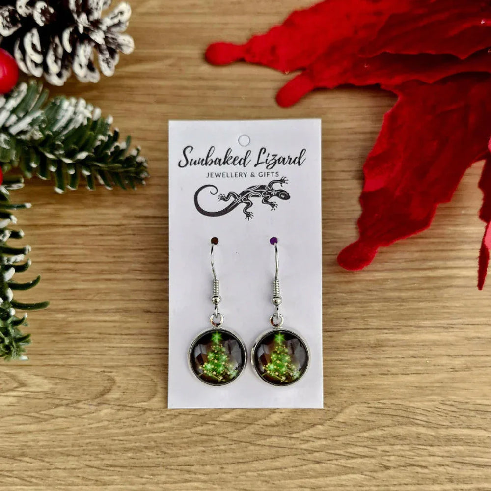 Earrings on a display card with decorative elements on a wooden surface