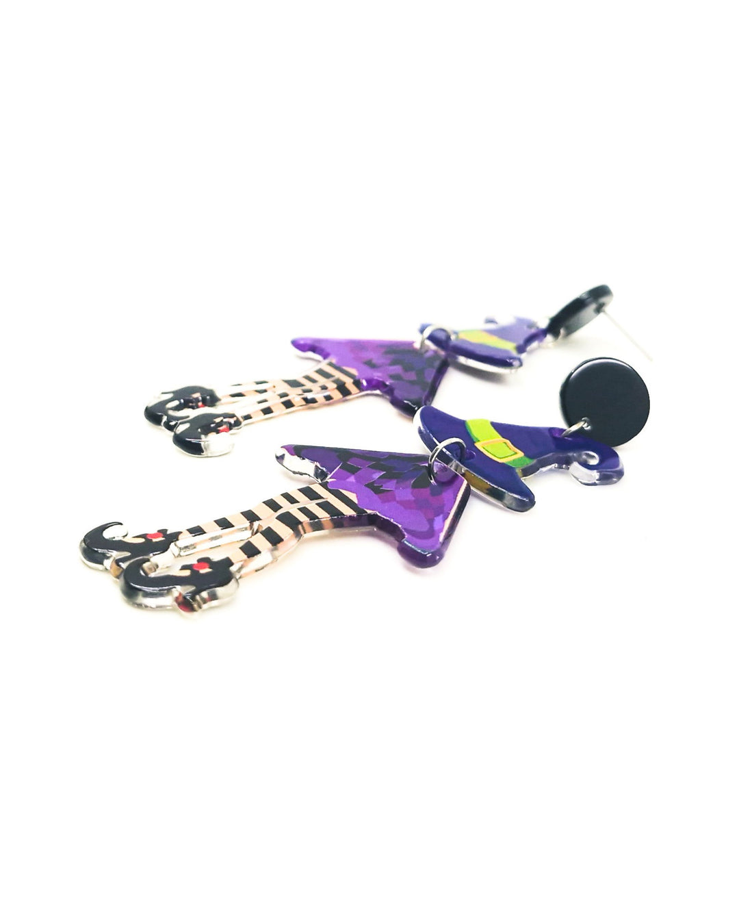 Angled view of jointed witch Halloween earrings showing purple hat, bat-print dress and striped legs