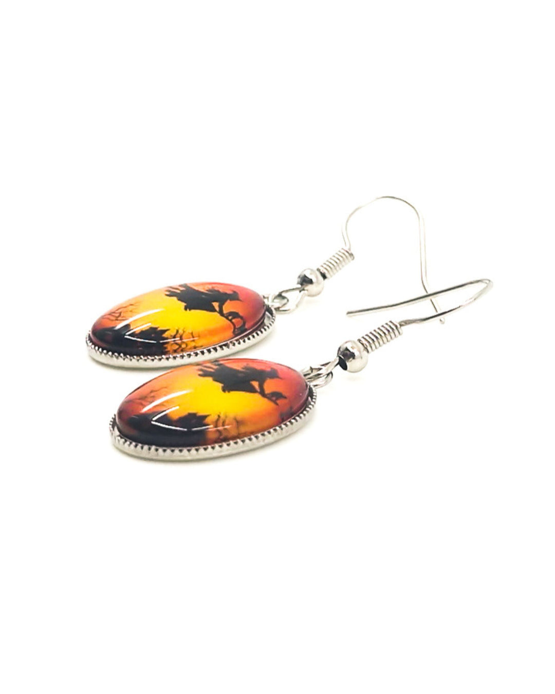 Cloe up of Witch on a broomstick oval drop earrings, showing cat on broom and haunted house