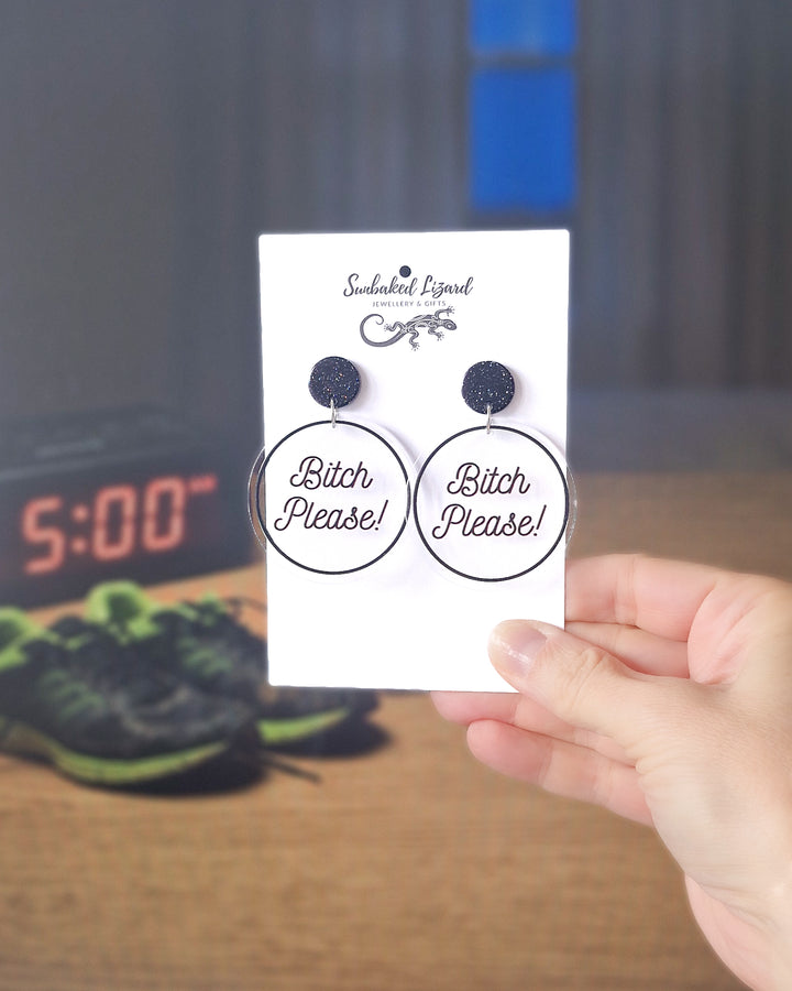Bitch Please black acrylic statement earrings displayed on a Sunbaked Lizard card in a lifestyle setting.