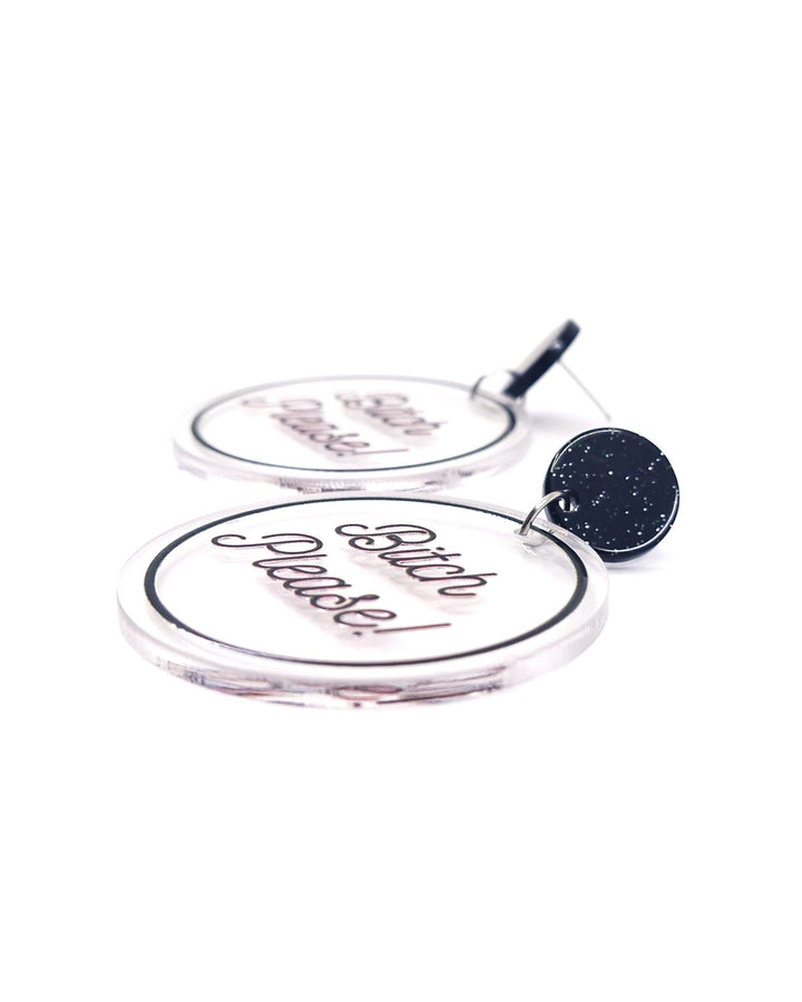 Close-up of Bitch Please acrylic statement earrings with black script, clear round charms and glitter black studs.