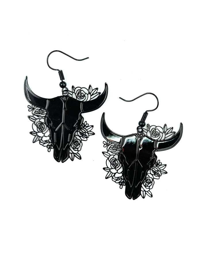 Black filigree bull skull drop earrings with rose cut-out detail on white background