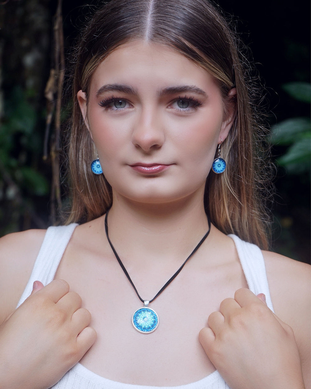 Model wearing Blue Mandala earrings and necklace featuring a vibrant blue glass cabochon in a silver-toned setting