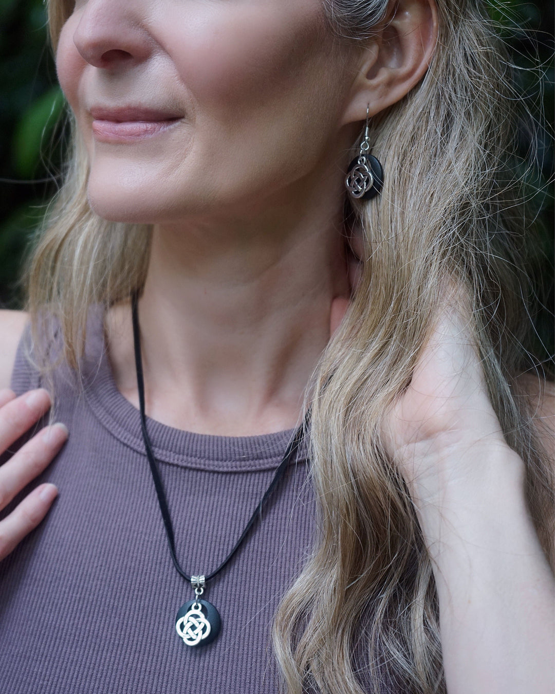 Model wearing the matching Celtic Knot jewellery set featuring a symbolic silver charm and coordinating earrings.