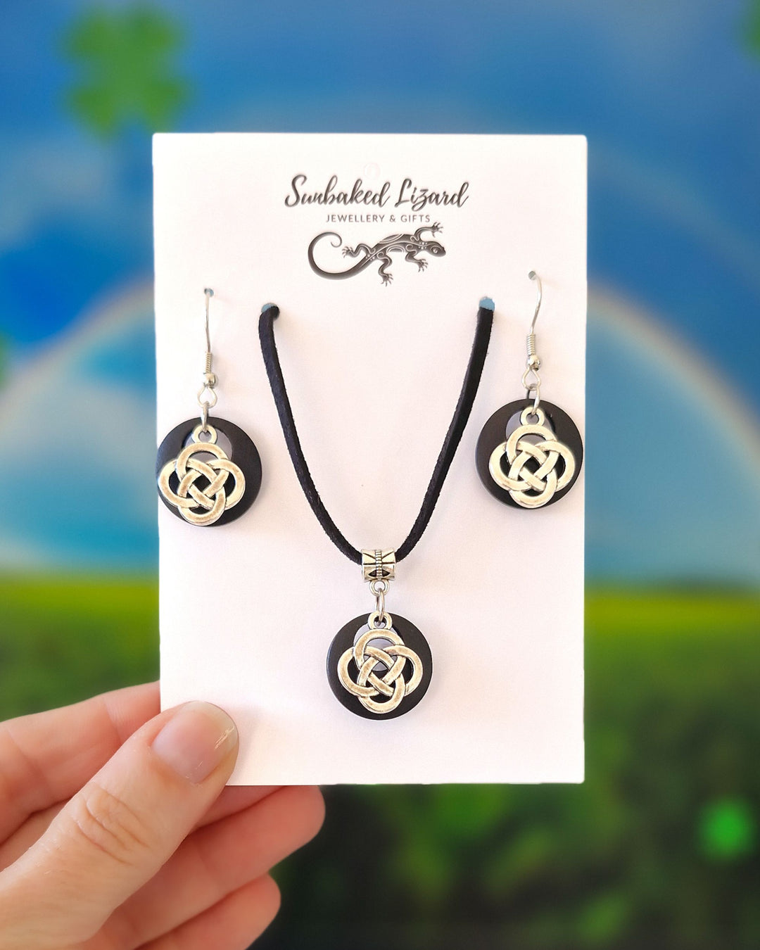 Celtic knot jewellery set with matching necklace and earrings on Sunbaked Lizard card against green background
