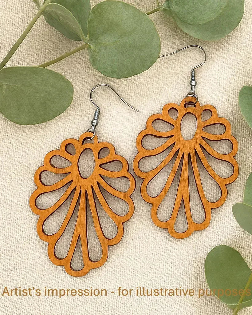 Claire Timber Drops open floral wooden earrings in warm natural timber, displayed on neutral fabric with green eucalyptus leaves.