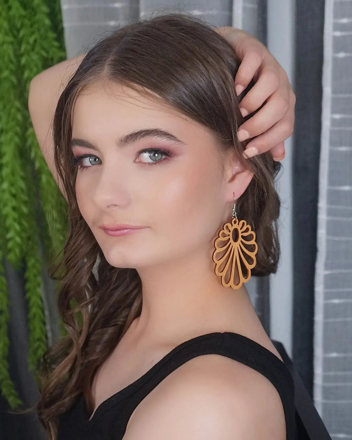 Claire Timber Drops worn – lightweight open-cut floral wooden earrings in natural timber, side view showing length and movement.