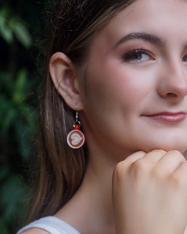 Model wearing Coffee and Cake earrings, with a close-up of the latte earring from the quirky food earring set.
