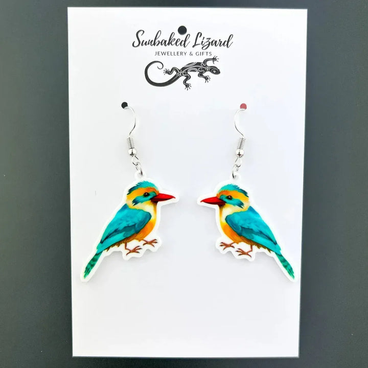 Colourful kingfisher drop earrings, two mirrored turquoise and orange birds with red beaks on silver hooks on Sunbaked Lizard backing card