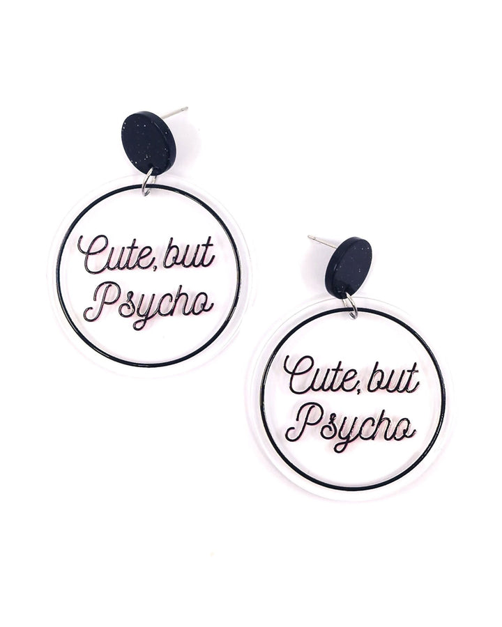 Cute But Psycho acrylic statement earrings with black lettering on clear round drops and black glitter studs.