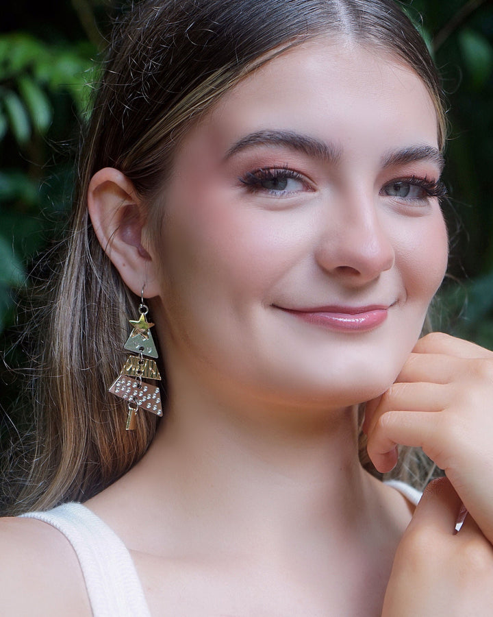 Model wearing Elegant Christmas Tree Earrings with layered silver and gold Christmas tree charms, perfect for festive outfits.