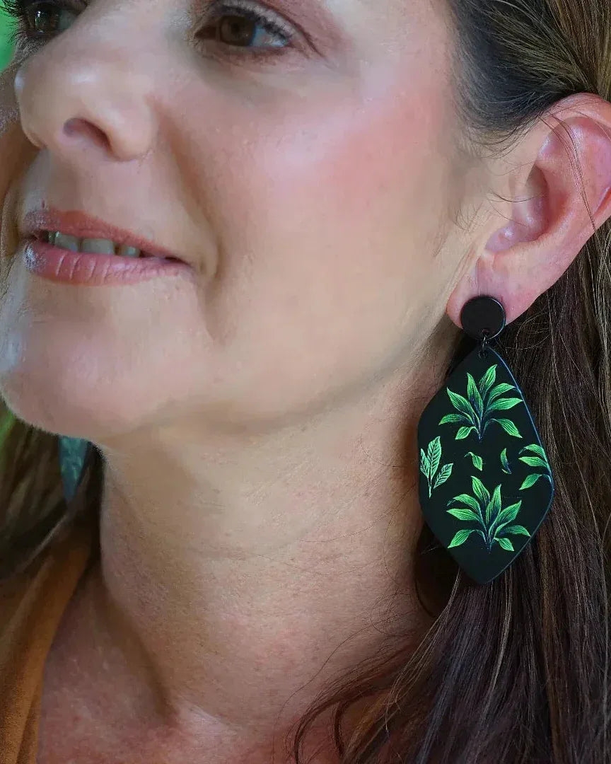 Side view of fern botanical statement drop earrings on model