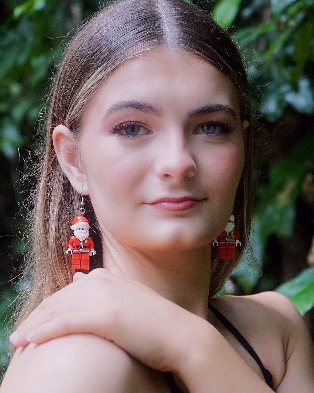 Model wearing Fun Toy Santa Christmas Earrings with playful block-style Santa charms for festive outfits.