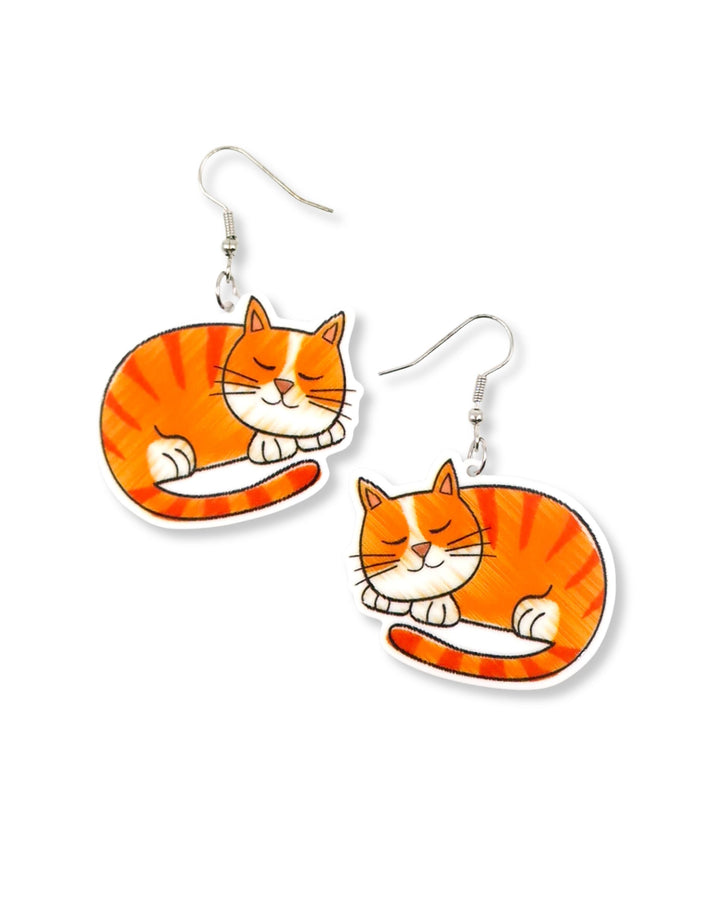 Pair of large ginger cat drop earrings with sleeping orange tabby design and silver hooks on a light background.