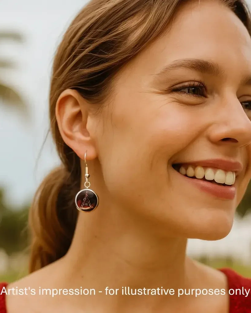 Model wearing a gold ribbon Christmas tree earring, showing the size against her ear